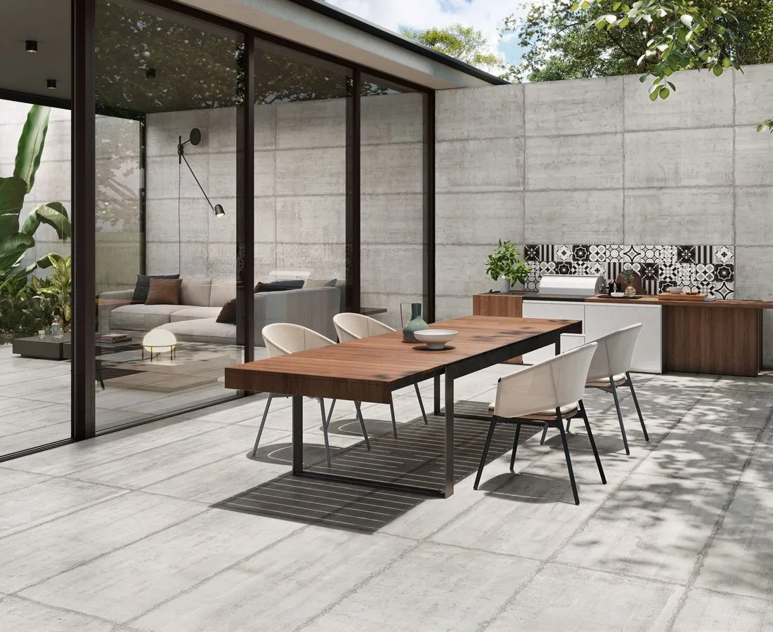 Patio esterno con pavimento in gres effetto cemento e parete decorata